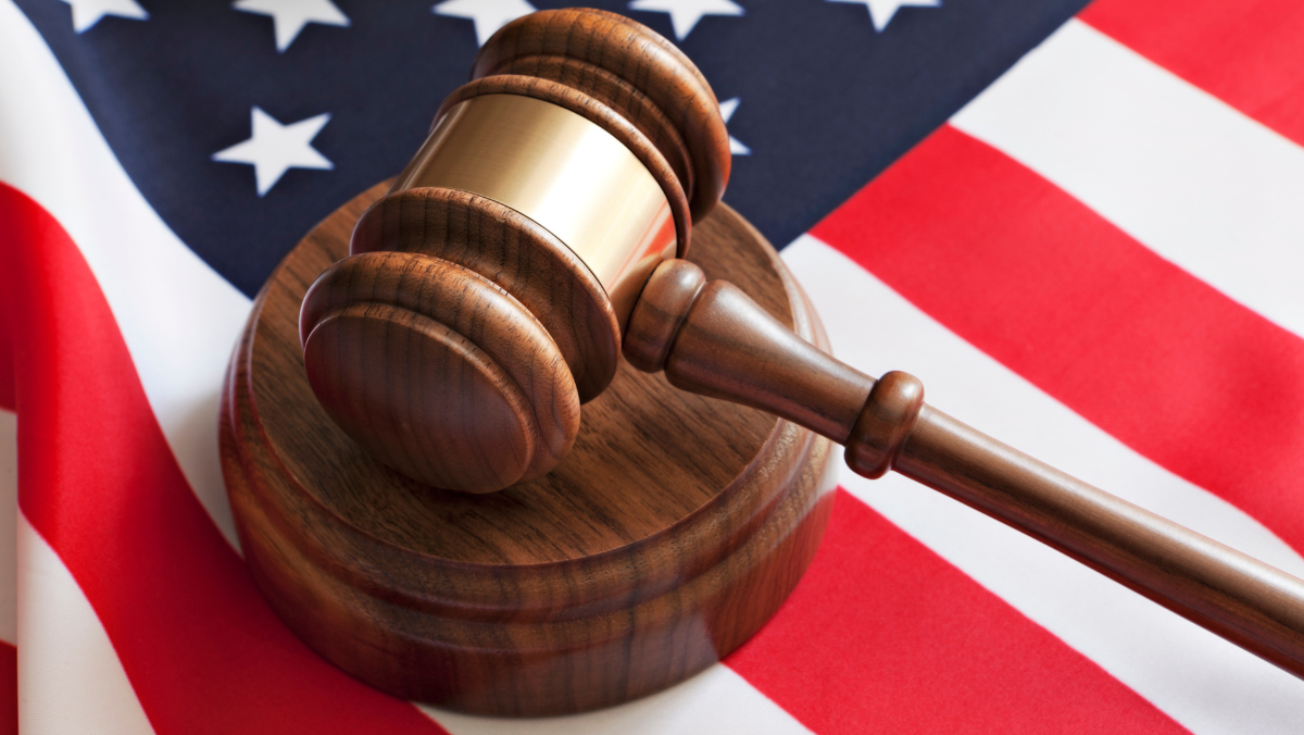Judge’s gavel resting on U.S. flag symbolising regulatory and legal decisions.