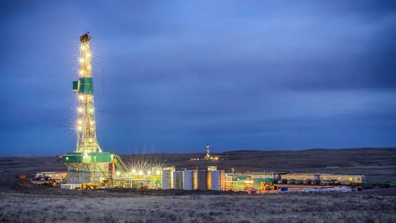 Drilling rig illuminated at night at an onshore energy site