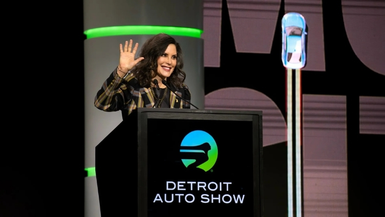 Governor at Detroit Auto Show podium with event branding