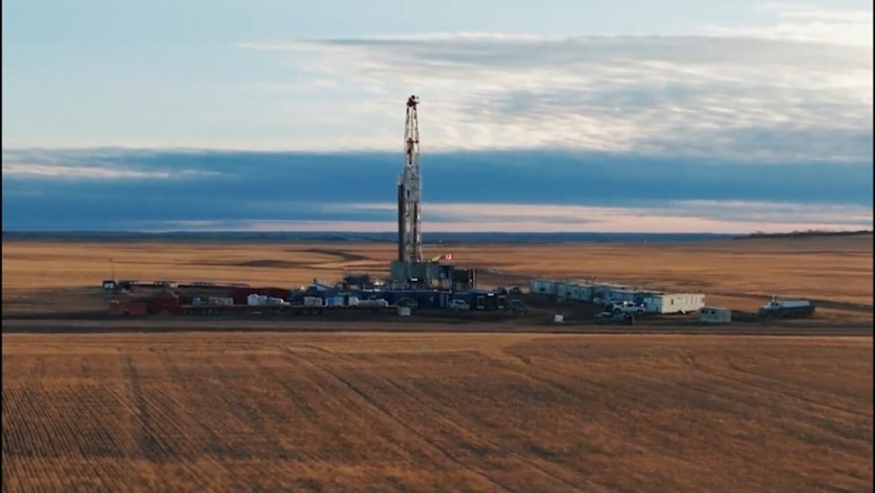 Drilling rig operating on open prairie farmland